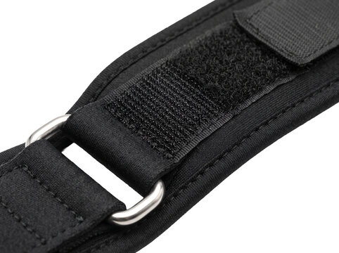 Black tactical strap buckle fastener with hook and loop tape closeup isolated on black background for athletic gym fitness gear orthopedic brace support equipment heavy duty nylon belt harness