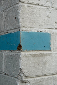 Angle de mur avec briques peintes en blanc et insert de carreau &eacute;maill&eacute; bleu turquoise pour d&eacute;corer