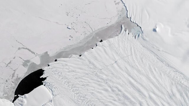 Aerial view on glacier flowing into sea, cracking in pieces making icebergs. Camera is moving backward and left. Animation based on image by NASA
