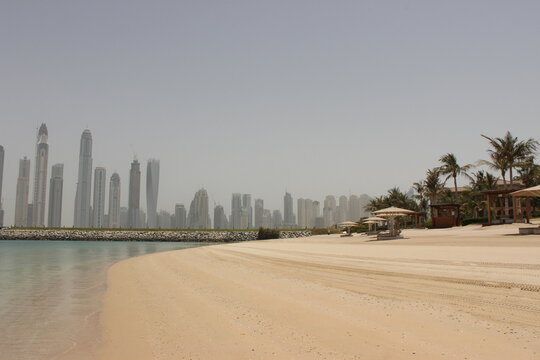 Dubai skyline with a sandy beach and calm turquoise water