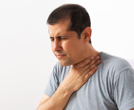 Man suffering touching painful neck, sore throat for flu, cold and infection with white background