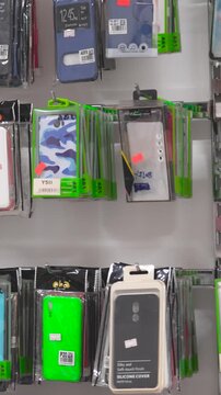 Wall display of colorful mobile phone cases in retail shop interior