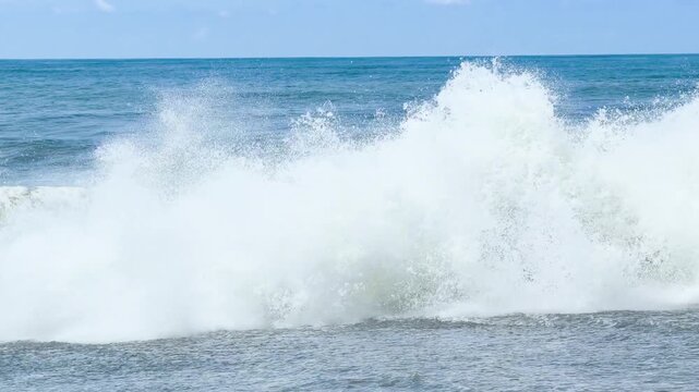 Blue sea and large waves and foam. Wave splashing over pebbles at sea. Rolling ocean waves. Summer beach background. Powerful sea waves	