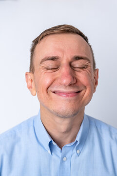 Man with eyes closed and a genuine, joyful smile, conveying happiness, contentment and relaxed well being against a clean white background, headshot emotion