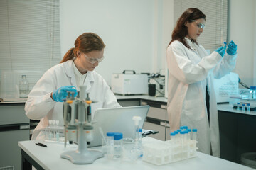 Fototapeta premium Two Caucasian Female Scientists Conducting Research Experiment with Lab Components and Equipment
