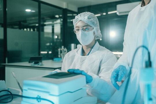 Female Scientist Operating Moisture Analyzer in Food or Pharmaceutical Industry Quality Control Laboratory