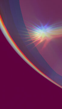 An abstract colorful light pattern with rainbow rays on a purple