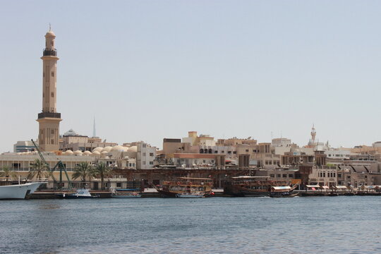 Dubai Creek skyline with traditional boats and a prominent minaret