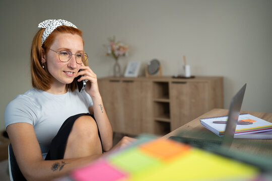 White Woman working from home talks on the phone