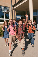 Obraz premium Group of Happy Diverse Schoolchildren Running Out of School Building Celebrating End of Class