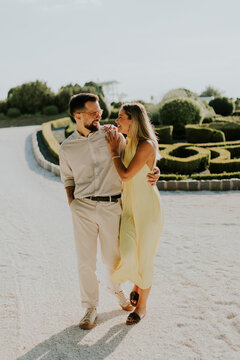 Couple shares joyful moments walking through a beautiful garden path