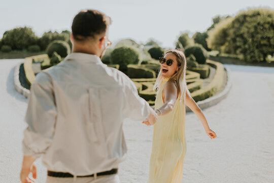 Couple enjoying a joyful moment in a picturesque garden on a sunny day
