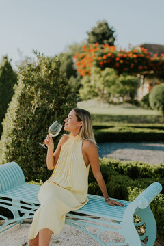 Enjoying a drink on a bench in a garden during a sunny day in the countryside