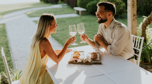 Couple enjoys a romantic toast while dining outdoors at sunset