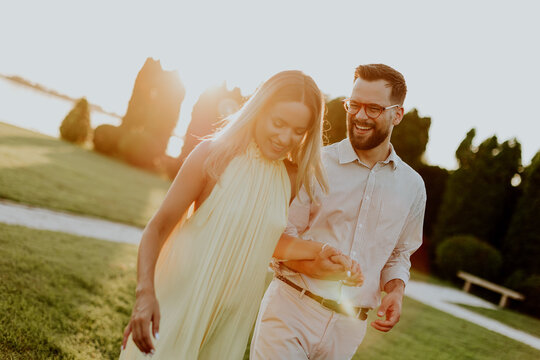 Couple walks together during sunset in a park near water