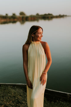 Serene moments by the water with a beautiful woman at sunset