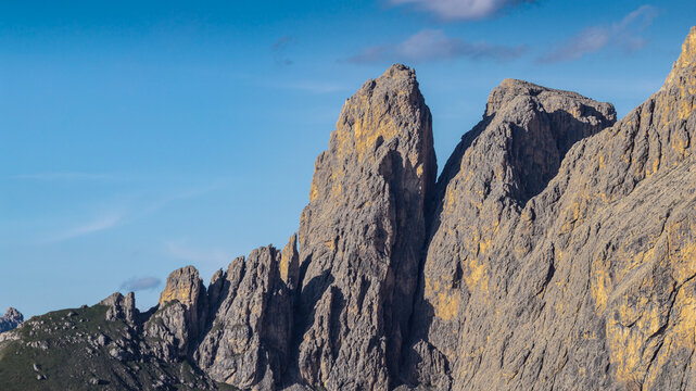 Aerial view of Sella Pass featuring jagged limestone peaks of the Dolomites under a clear blue sky in Selva, Trentino-Alto Adige, Italy.