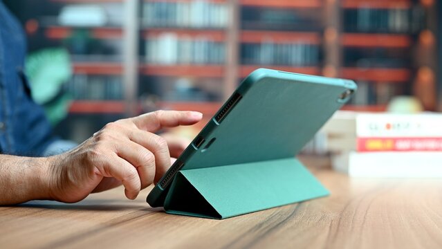 Student read book inside university library. Person read stack near bookshelf shelf bookshop store background interior college research hand. Read text, learn science, learn knowledge, school exam.