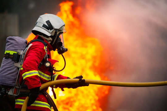 Firefighter team spraying water to extinguish fire in industrial zone