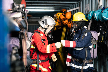 Fototapeta premium Two firefighters bumping fists in station locker room showing teamwork