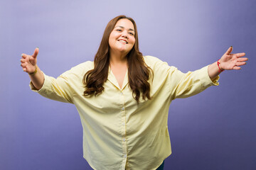Happy woman welcoming with open arms, embracing body positivity, and showing warm friendly greetings © AntonioDiaz
