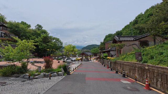 Paved walkway through hillside greenery in Jaman Mural Village, Jeonju, South Korea.