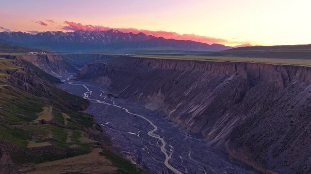 Aerial view of a deep river gorge during sunset with a colorful twilight sky in Anjihai Grand Canyon, Xinjiang, China
