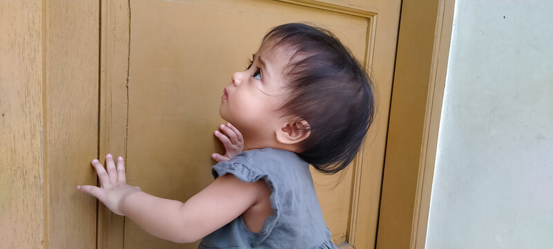Active one year old toddler enjoying a solo moment on the quiet home terrace
