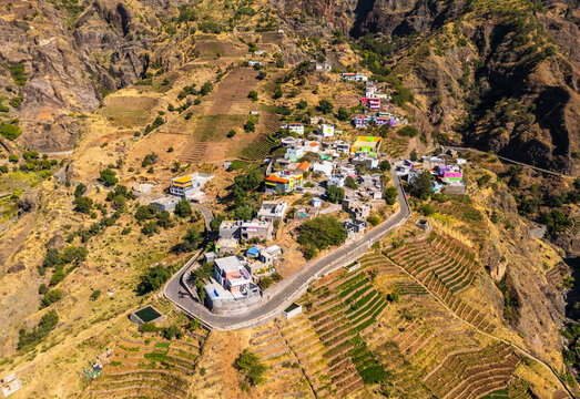 Aerial view of the village of Alto Mira nestled in the rugged volcanic mountains of Santo Antao, featuring terraced fields and winding roads in Alto Mira, Porto Novo, Cabo Verde.