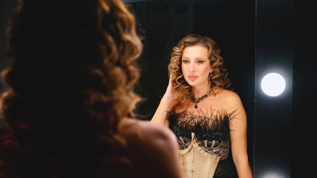 fantasy happy retro lady in short mini dress back rear view looking into mirror straightens her blonde curly hair. sexy woman smile face burlesque show. flapper girl dancer 20s roaring twenties 4k.