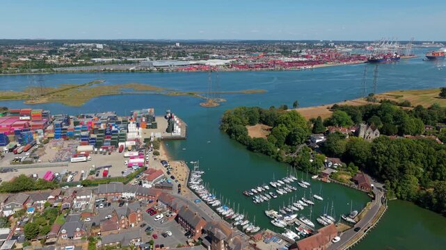 Aerial view of yachts moored in Eling with shipping containers and Southampton cargo port in the background in the UK