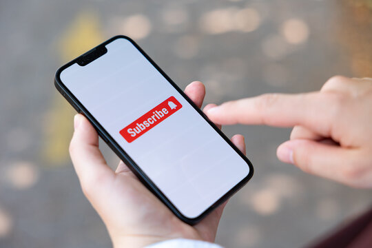 Subscribe icon, a woman with a smartphone taps the subscribe button on the screen, social media. Internet, newsletter, e-commerce, mobile app, wireless technology.
