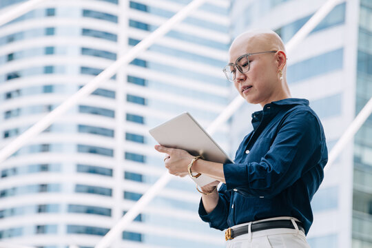 Modern Asian Business Artist Woman, Fashion Stylish Designer Investor with Bald head unique Personality in Urban city office building.