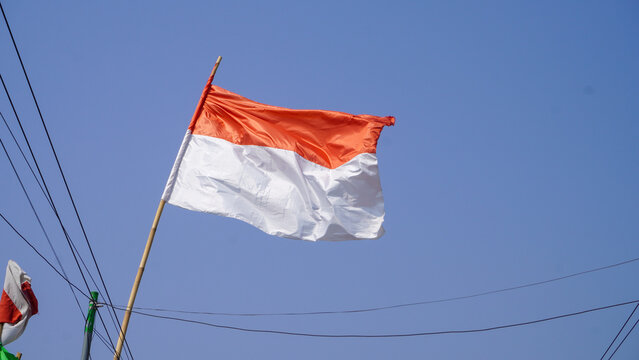 Indonesian red and white national flag waving proudly against a clear blue sky, perfectly capturing the vibrant spirit and patriotic pride for Indonesia's 81st Independence Day anniversary celebration