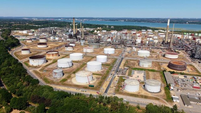 Aerial view of massive oil refinery with storage tanks, pipework, and exhaust stacks in Fawley UK