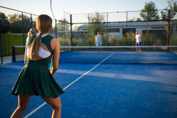 Fototapeta premium Female padel player waiting on blue court