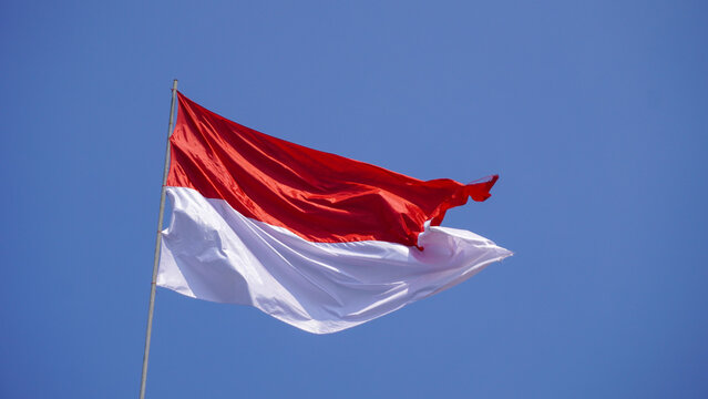 Indonesian flag red and white fluttering high against a bright blue sky for the 81st Independence Day.