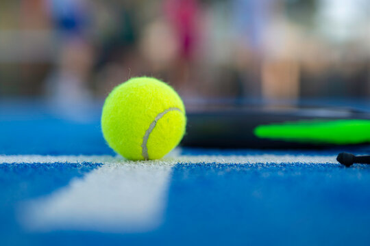 Tennis ball resting on blue court line