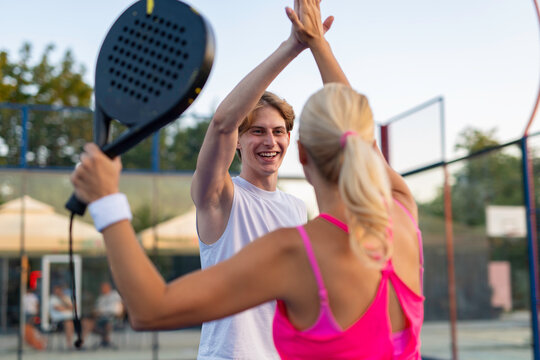 Padel players high fiving celebrating victory