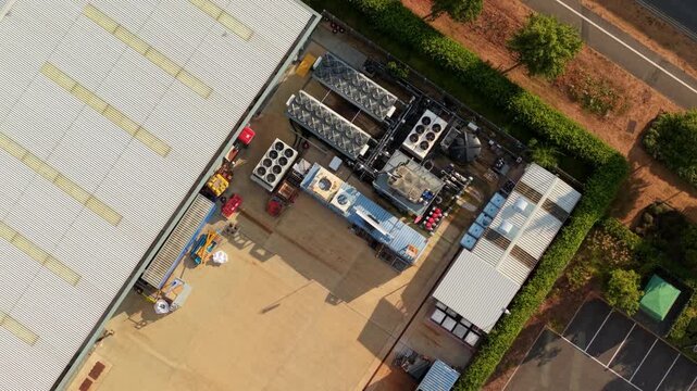 Top Down Aerial Shot of Industrial Rooftop Cooling Fans and Air Handling Units on Tech Facility