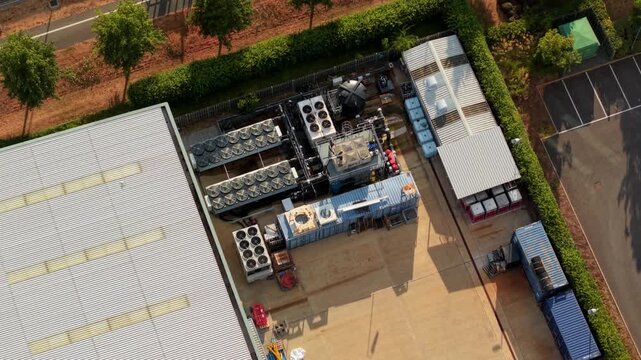 Top Down Aerial Shot of Industrial Rooftop Cooling Fans and Air Handling Units on Tech Facility