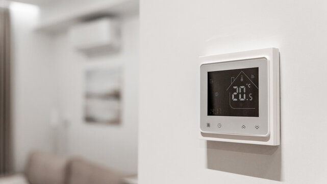 white thermostat for underfloor heating and climate control systems. control panel. apartment, house, hotel. smart home. automatic heating system. technology. stylish designer expensive repair