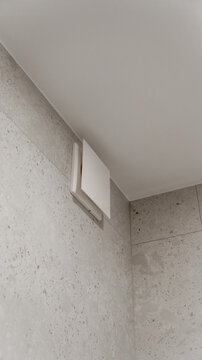 white exhaust fan in the bathroom on the tile. decorative white plastic panel. technology. stylish designer expensive renovation