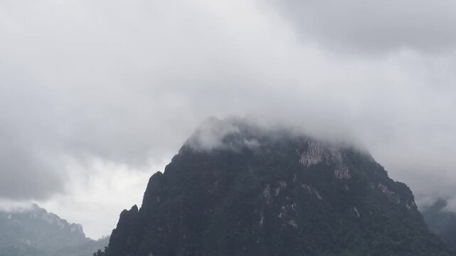 Ratchaprapha Dam on a rainy day at khao sok national park, surat thani province thailand featuring spectacular limestone mountains shrouded in mist.