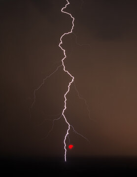 striking lightning bolt during a dark sky with partial solar eclipse natural phenomenon