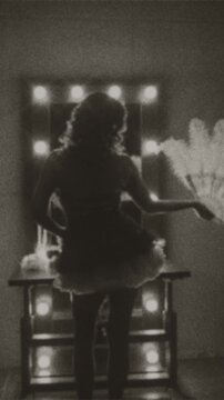 Black and white film color old style silhouette retro lady looking into mirror hand holding fan white ostrich feathers. sexy woman burlesque show dancer back view. Flapper girl 20s roar vertical video