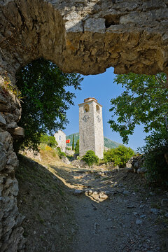 Ancient stone tower framed by rocky arch in historic Stari Bar