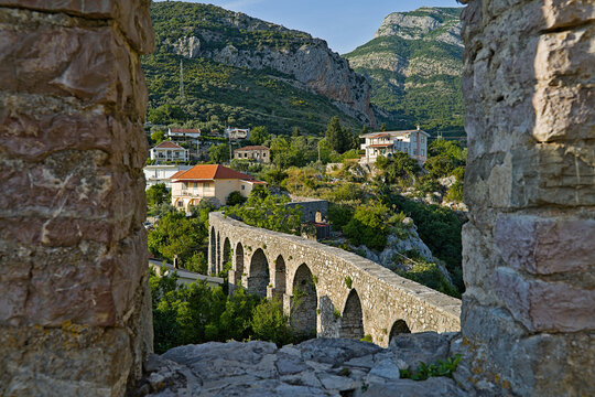 Ancient stone aqueduct in Stari Bar, Montenegro, framed by historic ruins