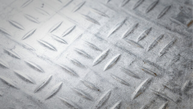 Industrial grey metal diamond plate texture with raised slip-resistant pattern