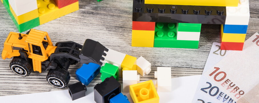 Houses made of toy blocks, miniature excavator, mortgage agreement form and euro banknotes. Financing building or purchase of real estate